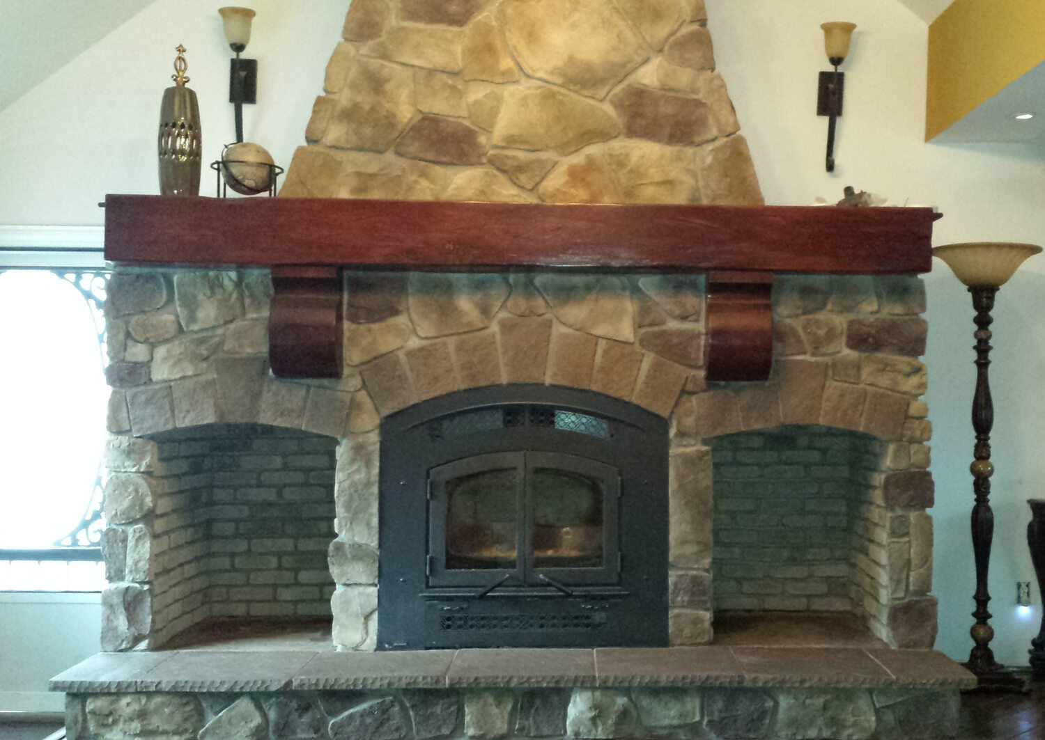 Custom interior stone fireplace with a mahogany mantel and wood-burning insert