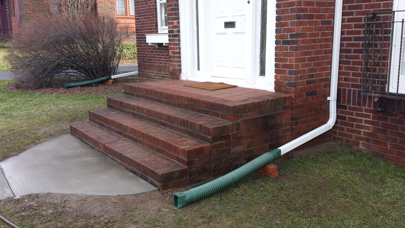 Rebuilt red brick front entry steps with a fresh concrete walkway