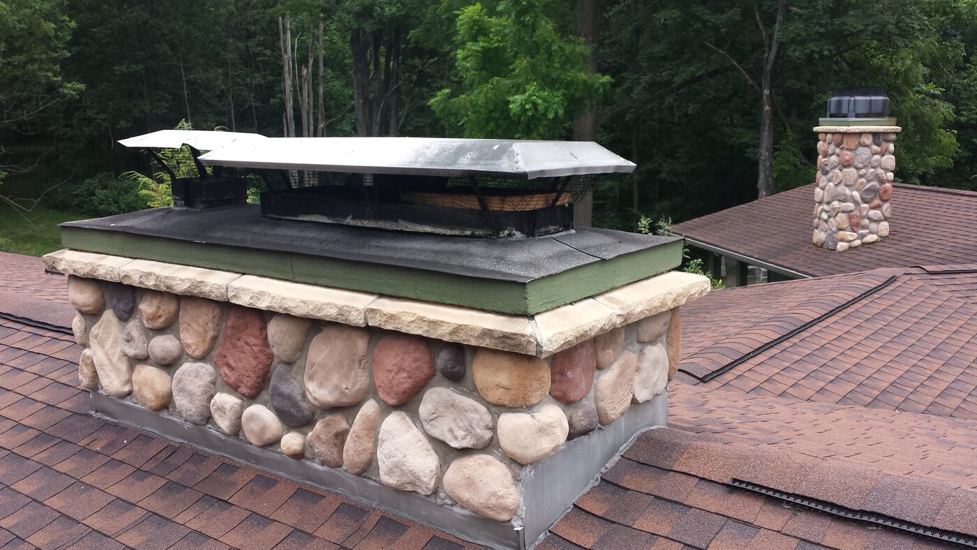 Fieldstone chimney finished with a new stainless steel chase cover
